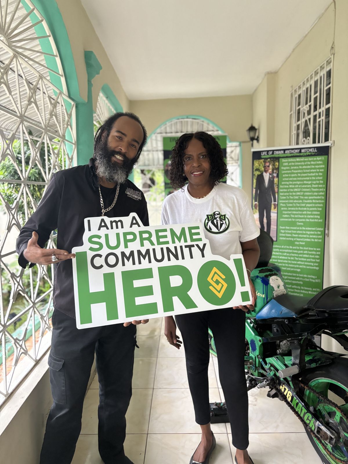 Biggz General holding the I Am A Supreme Community Hero sign